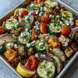 Roasted Mediterranean Greek vegetables served warm from the oven with juicy tomatoes, onions, and a bright lemon drizzle.
