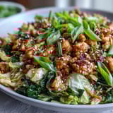 Weeknight Egg Roll Bowls feature juicy chicken, carrots, and crunchy cabbage finished with a drizzle of chili crisp and fresh ginger aromas.