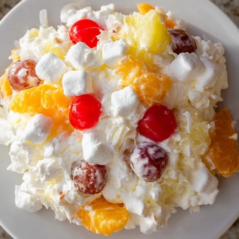 A vibrant bowl of Ambrosia Salad with juicy fruits and sweet, fluffy marshmallows.
