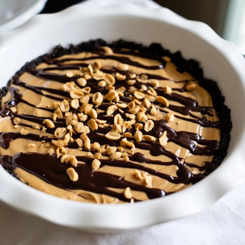 Freshly made Peanut Butter Pie, with a drizzle of chocolate and crunchy peanut topping.