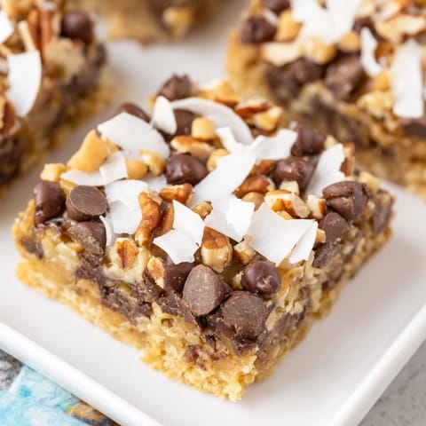 Golden, layered Magic Cookie Bars with a buttery graham cracker crust, a delicious treat.
