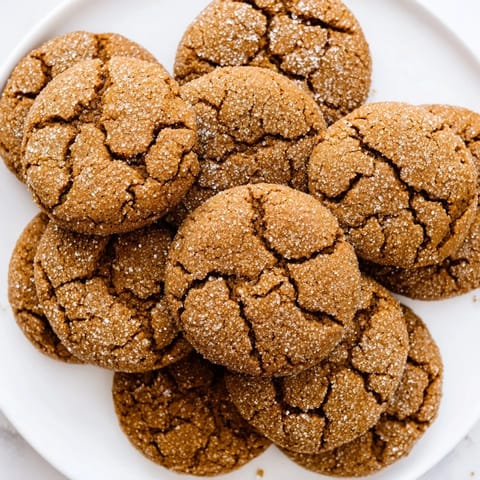 Close-up of freshly baked molasses cookies, glistening and ready to enjoy with a warm drink.