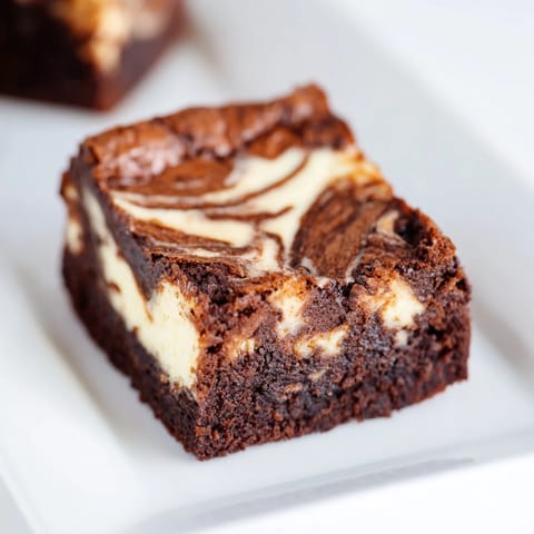 Delicious cheesecake brownies with a fudgy brownie base and creamy cheesecake swirl.