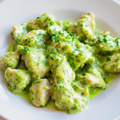 Overhead view of Green Goddess Chicken Salad plated on a white dish, showing crisp lettuce, sliced cucumbers, and vibrant green dressing for a fresh meal.