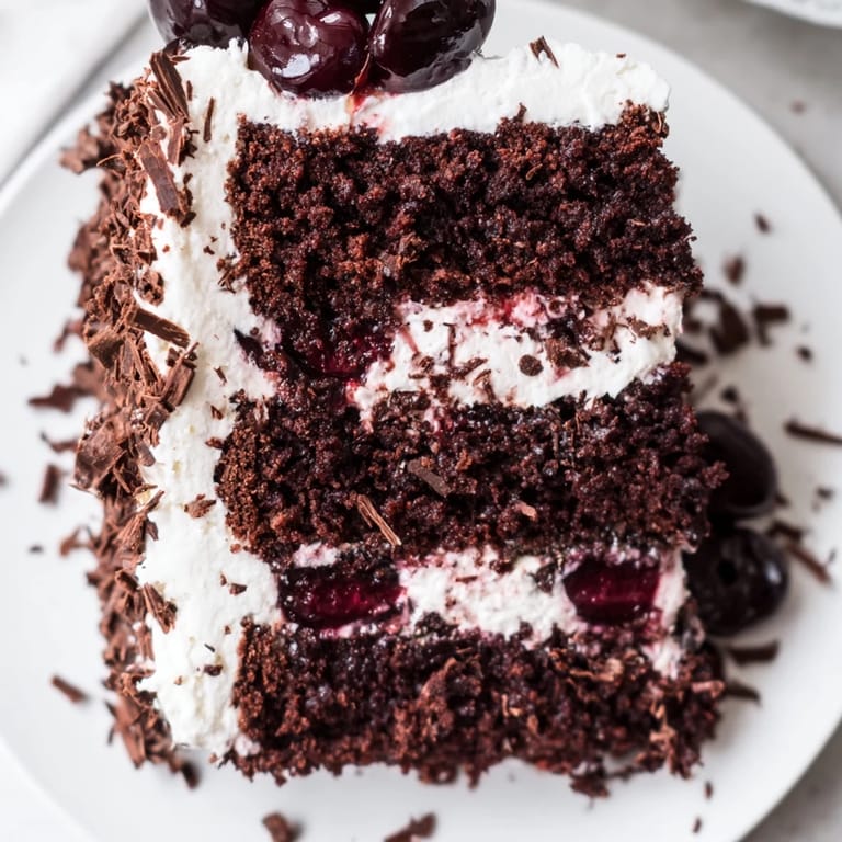 This delicious Black Forest Cake features a rich chocolate cake adorned with beautiful fresh cherries.