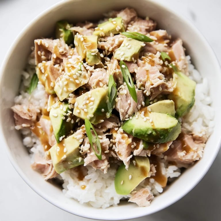 Colorful Tuna Avocado Rice Bowl served in a ceramic bowl, showcasing tender tuna and diced avocado against warm jasmine rice.
