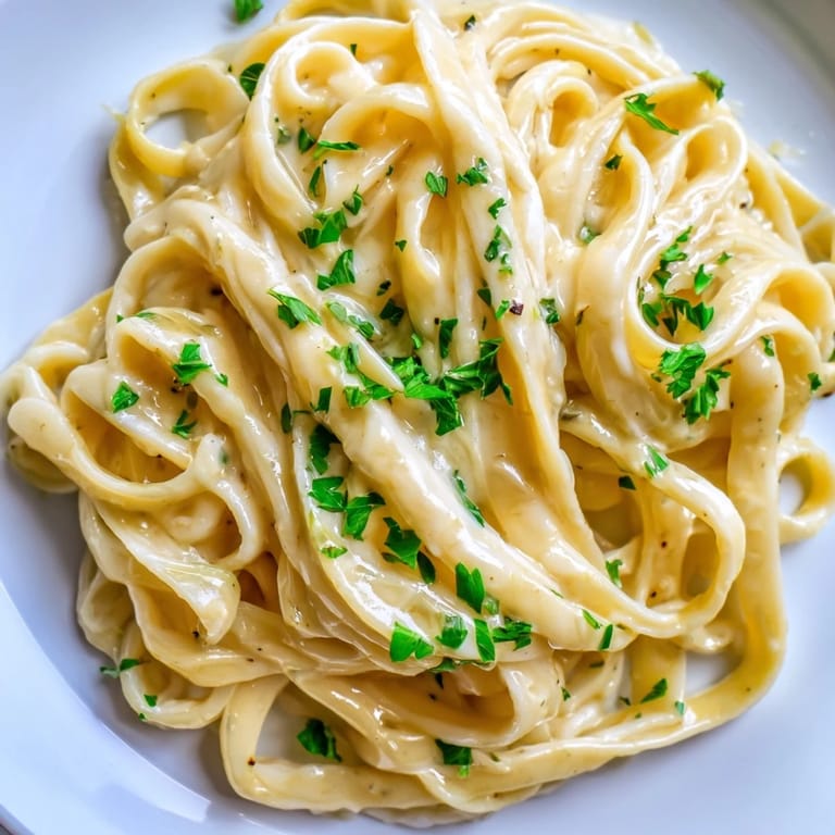 Steaming plate of vegetarian sriracha honey pasta garnished with fresh parsley and grated parmesan for a flavorful dinner.  